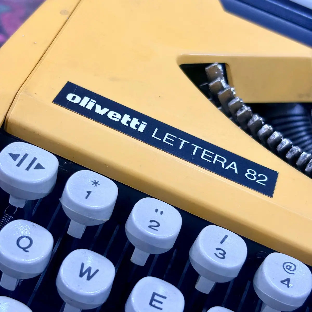 Close-up of white keys and yellow casing on Olivetti Lettera 82 manual typewriter at RR Typewriter Mart