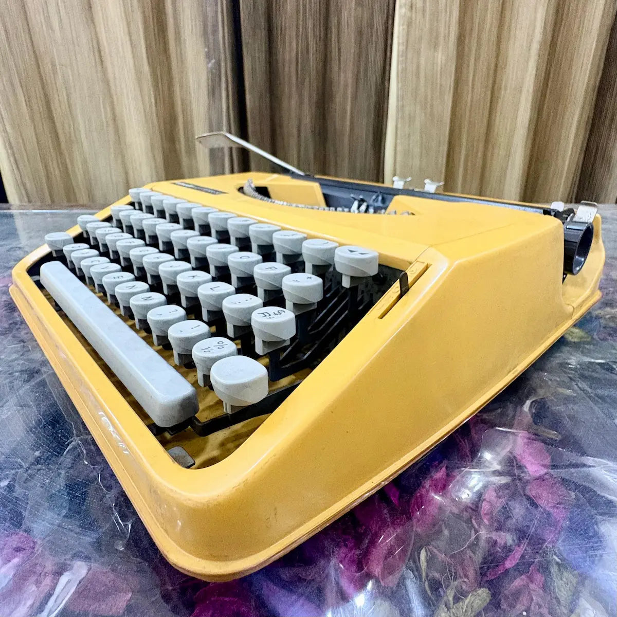 Low side angle of yellow Olivetti Lettera 82 typewriter showing body profile and keyboard at RR Typewriter Mart