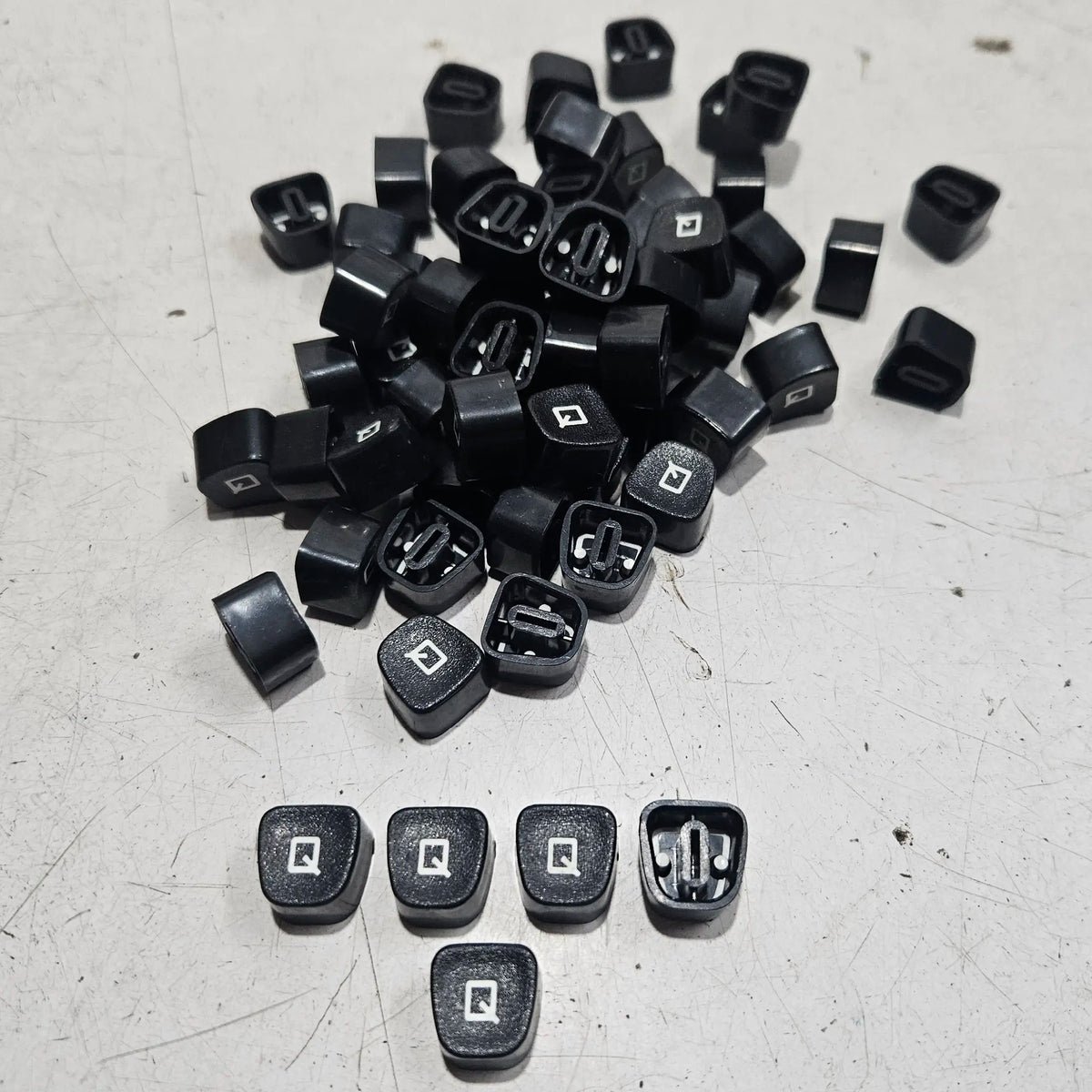 Close view of black Q typewriter keytops used in typewriter restoration and typing machine maintenance projects