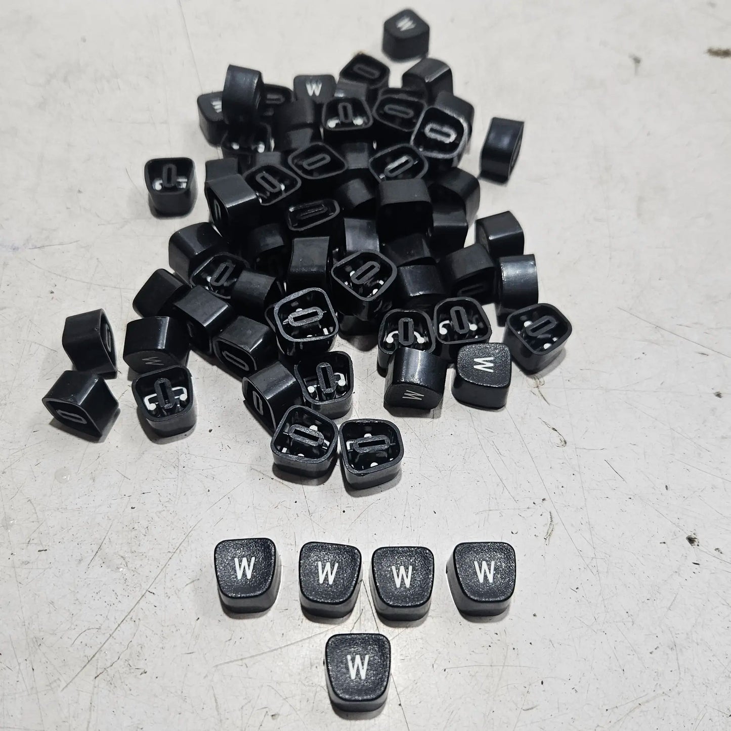 Close view of black W typewriter keytops used in typewriter restoration and typing machine maintenance projects