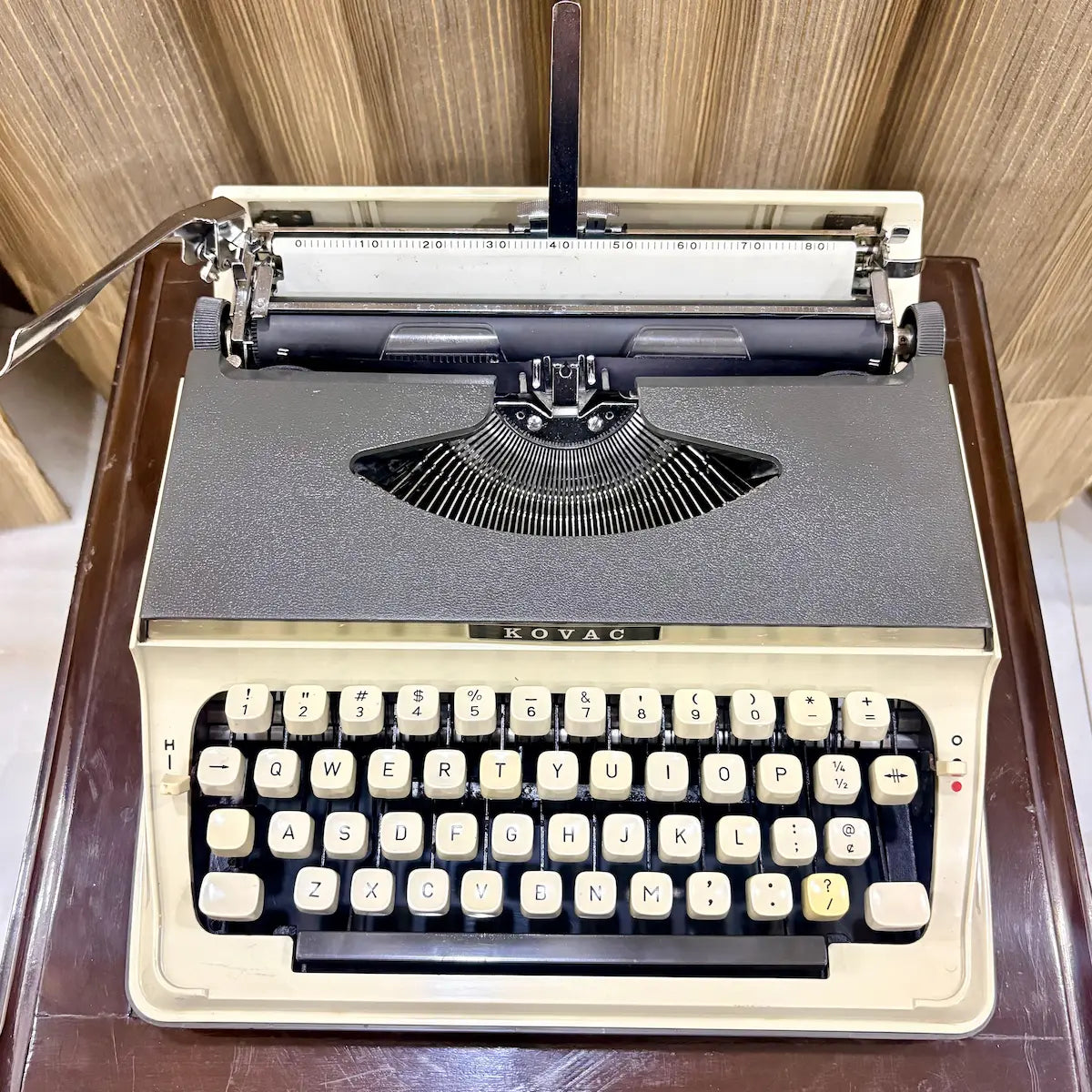Kovac M-101A Japanese manual typewriter in original grey and ivory white, featuring exposed typebars and cream keys, photographed from above | RR Typewriter Mart