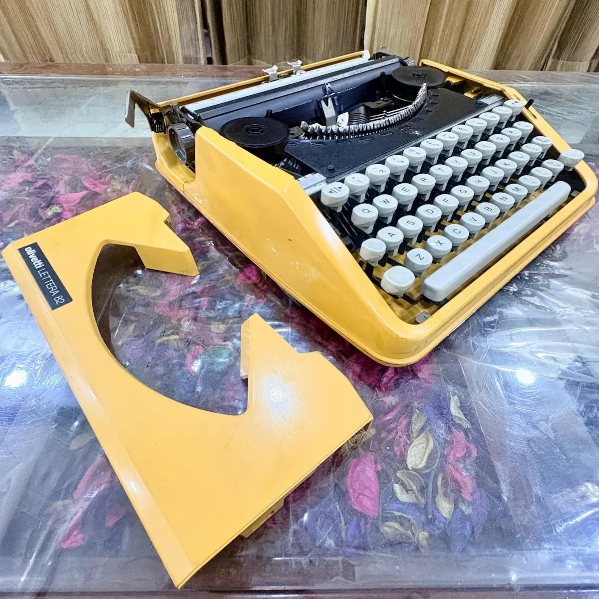Close angled view of Olivetti Lettera 82 yellow typewriter with white keys and exposed typebars at RR Typewriter Mart