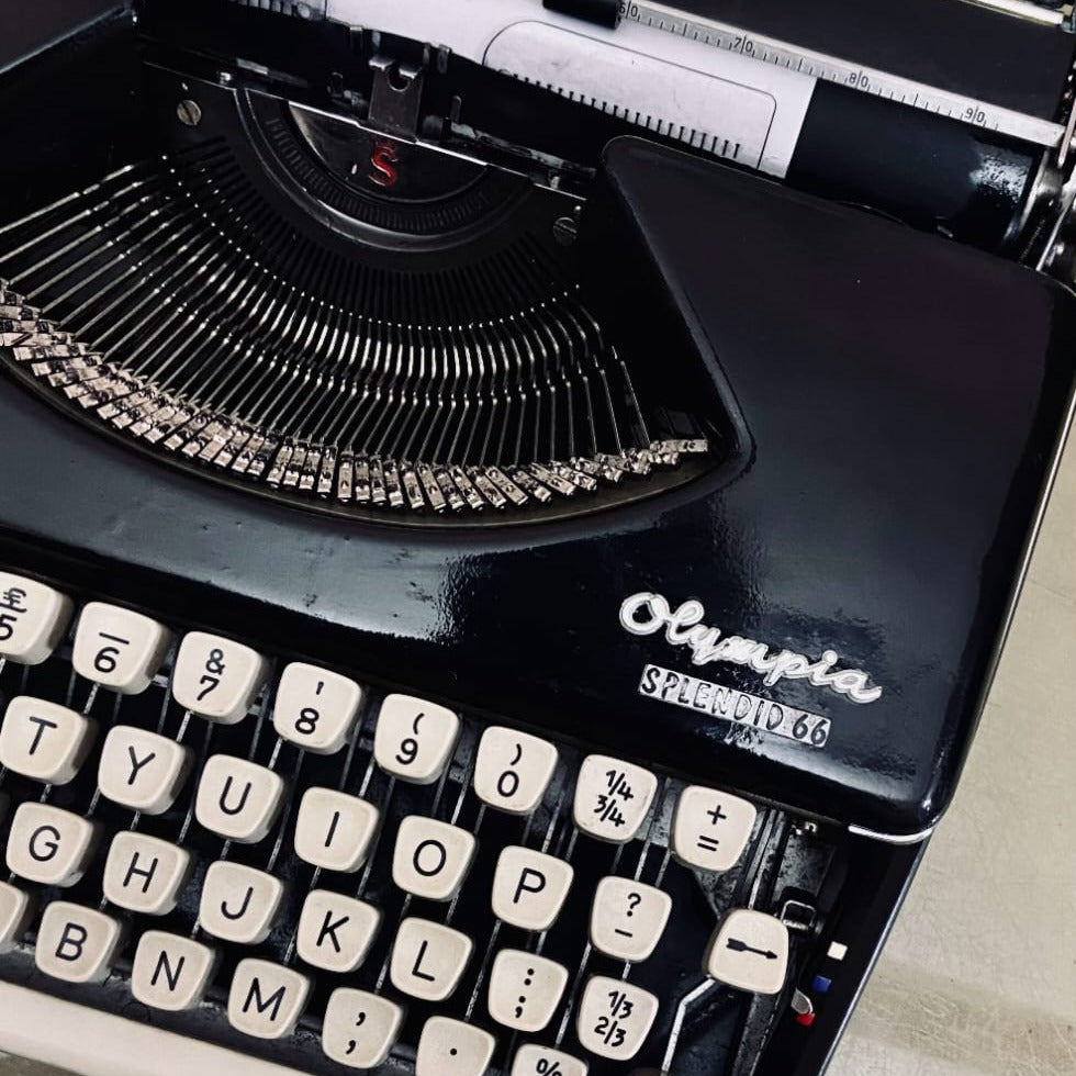 Close-up of Olympia Splendid 66 typewriter with cream keys, typebars and black body on German portable machine