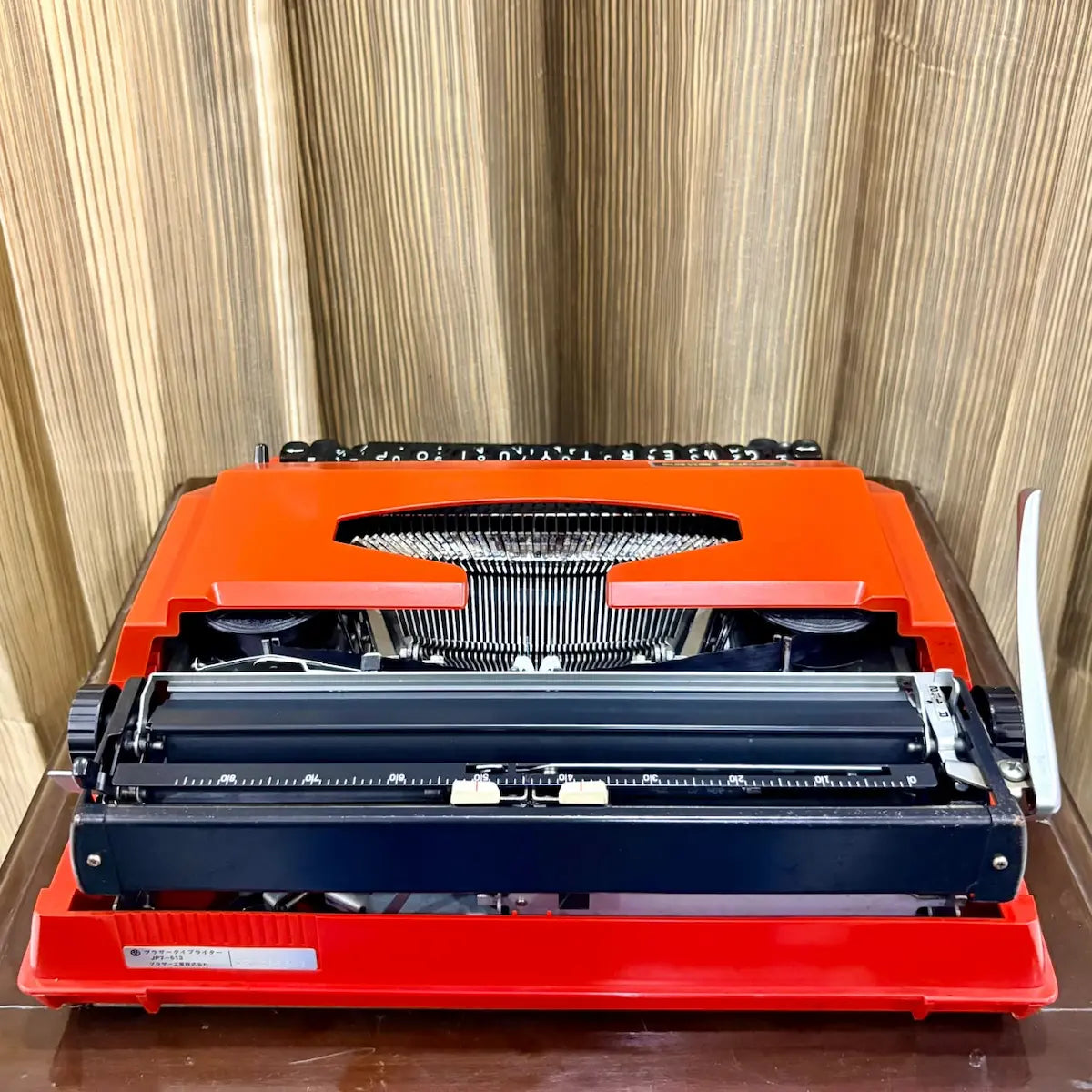 Close-up of Brother Young Elite 513 red typewriter body and keyboard edge, showing finish details on a vintage manual machine | RR Typewriter Mart