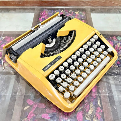 Yellow Olivetti Lettera 82 typewriter viewed diagonally, showing body and keyboard at RR Typewriter Mart