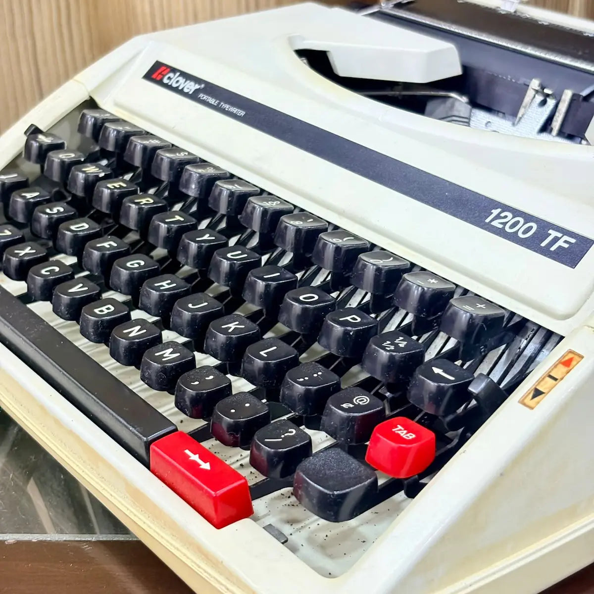Clover 1200 TF typewriter keyboard close view, black mechanical keys on cream portable manual typewriter