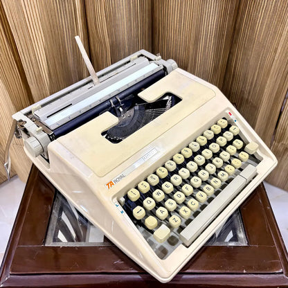 Royal Junior semi portable typewriter angled view showing cream body and mechanical frame, from RR Typewriter Mart.