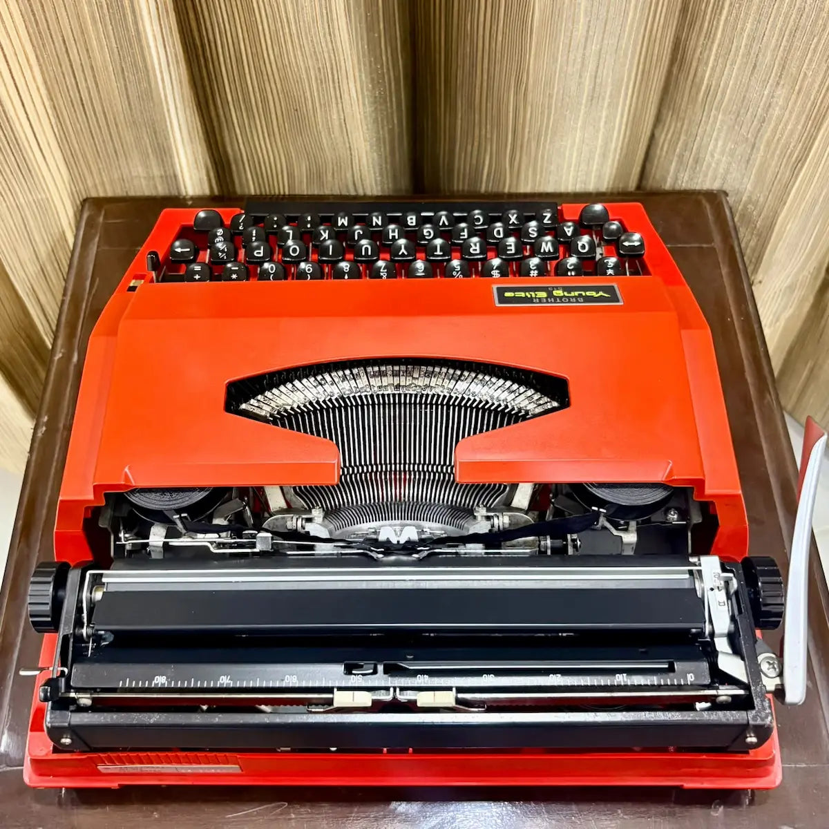Brother Young Elite 513 scarlet red portable typewriter, rear carriage view with platen and paper feed mechanism visible | RR Typewriter Mart