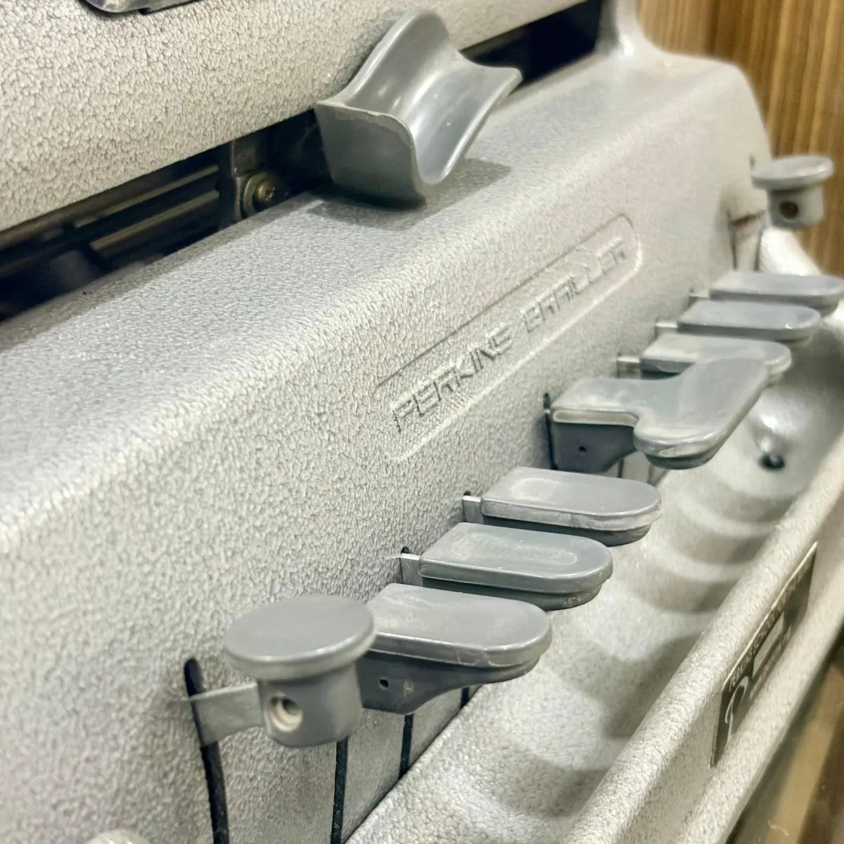 Angled view of the Perkins Braille Typewriter highlighting its American design and preserved factory paint at RR Typewriter Mart India.