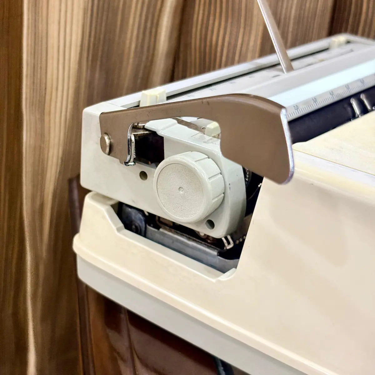 Royal Junior semi portable typewriter side view showing carriage, platen and cream body, from RR Typewriter Mart.