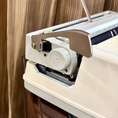 Royal Junior semi portable typewriter side view showing carriage, platen and cream body, from RR Typewriter Mart.
