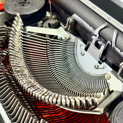 Scarlet red Brother Young Elite 513 typewriter with black keyboard, three-quarter view of vintage portable writing equipment | RR Typewriter Mart