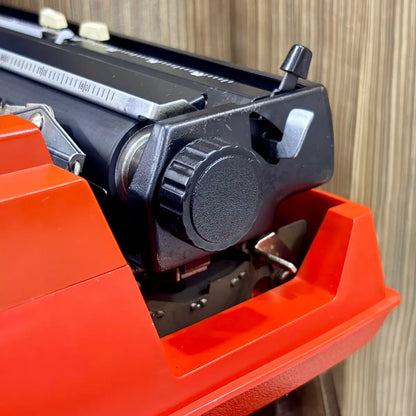 Brother Young Elite 513 red portable typewriter side profile, showing the compact housing and traditional manual typing mechanism | RR Typewriter Mart