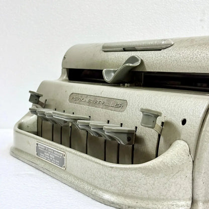 Perkins Typewriter with a durable cast-metal body and factory-original gold-toned paint for tactile Braille writing at RR Typewriter Mart