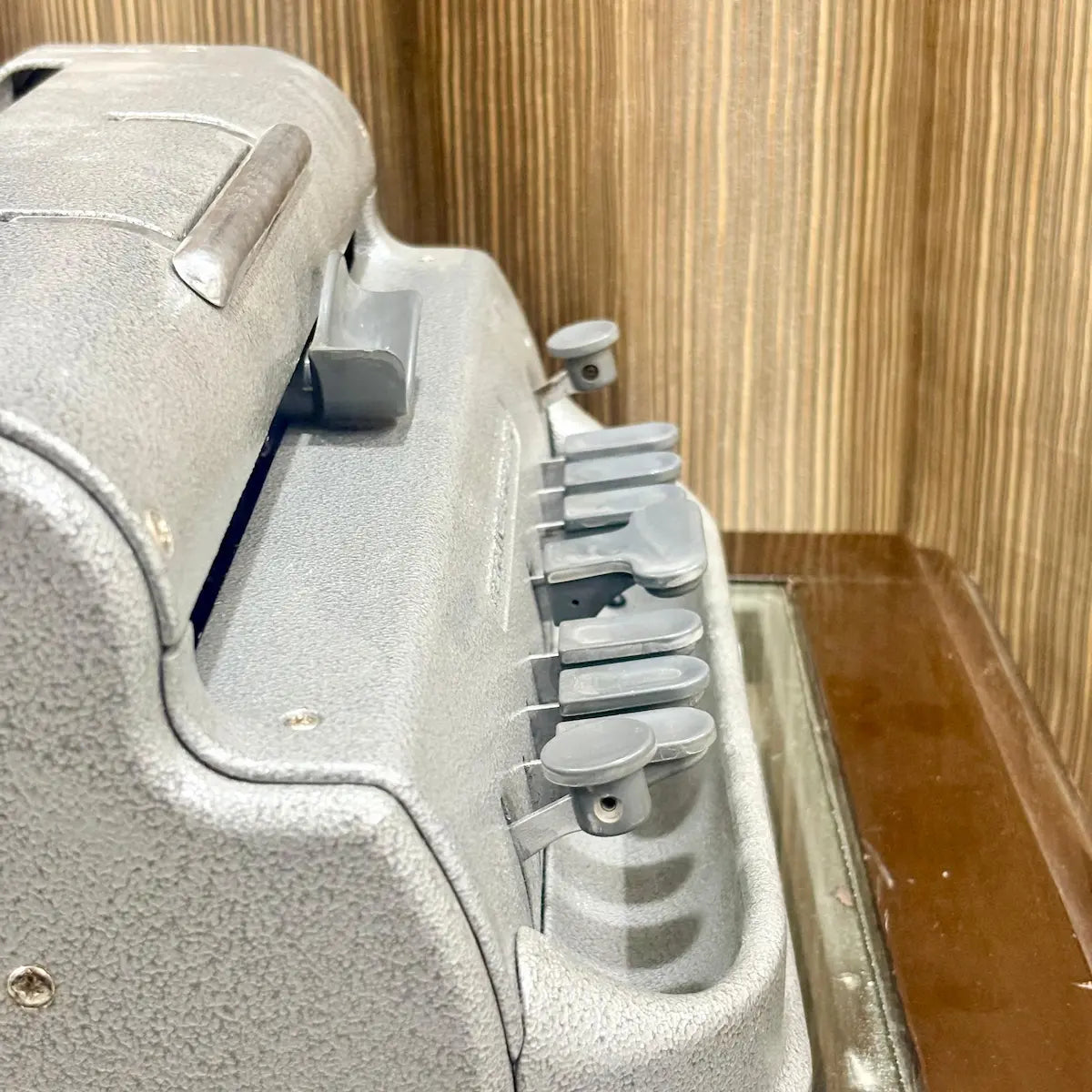 Angled close up of the Perkins Braille Typewriter showing its grey factory finish and key assembly at RR Typewriter Mart for Braille users.