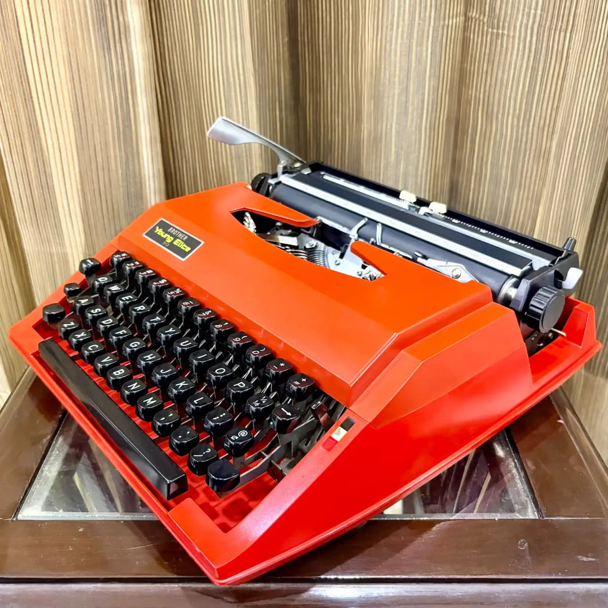 Brother Young Elite 513 scarlet red manual typewriter viewed from the rear, highlighting carriage and body construction | RR Typewriter Mart