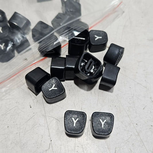 Black Godrej Y keytops displayed on a worktable, typing machine spare parts for manual typewriter repair work