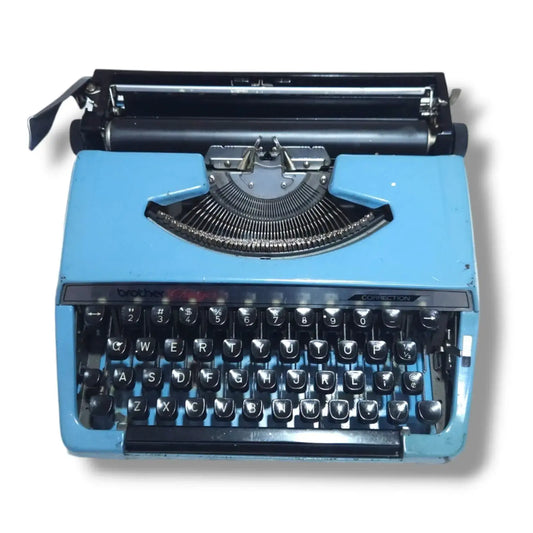 Front view of blue Brother Charger 11 Correction typewriter, portable manual English typing machine with black keys