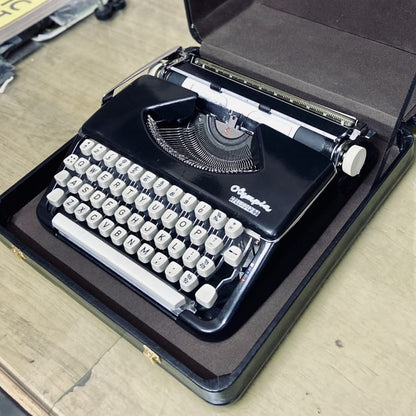 Black Olympia Splendid 66 typewriter in carry case, German portable manual English typing machine with cream keys