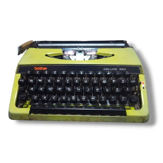 Front view of olive green Brother Deluxe 220 typewriter, vintage portable manual English typing machine with black keys