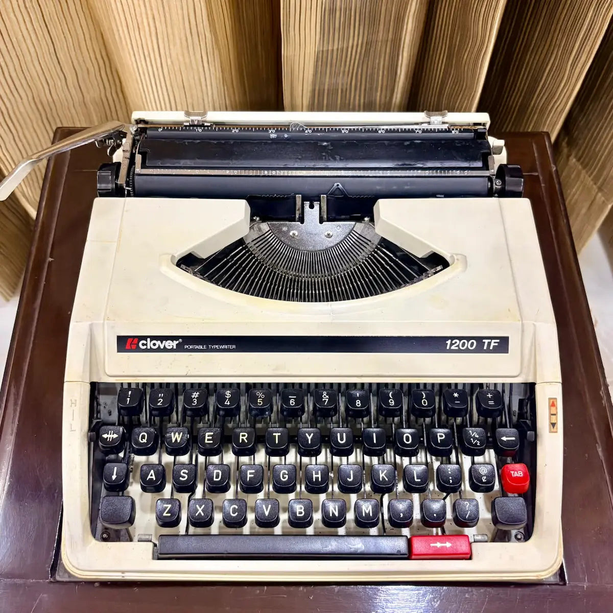 Clover 1200 TF portable typewriter front view, cream body and black keys, genuine manual typing machine