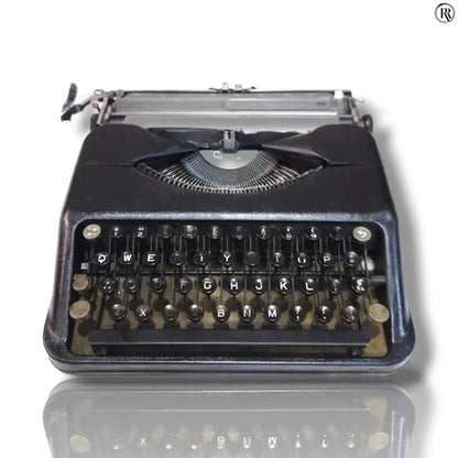 Black Hermes Baby typewriter front view, compact manual English typing machine with round keys at RR Typewriter Mart