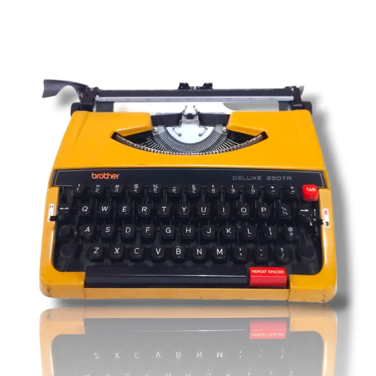 Brother Deluxe 250 TR yellow portable typewriter front view with black English keyboard, red keys and visible typebars