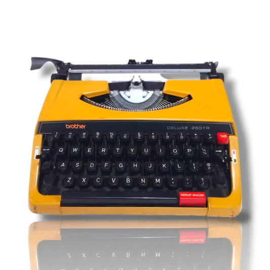 Brother Deluxe 250 TR yellow portable typewriter front view with black English keyboard, red keys and visible typebars
