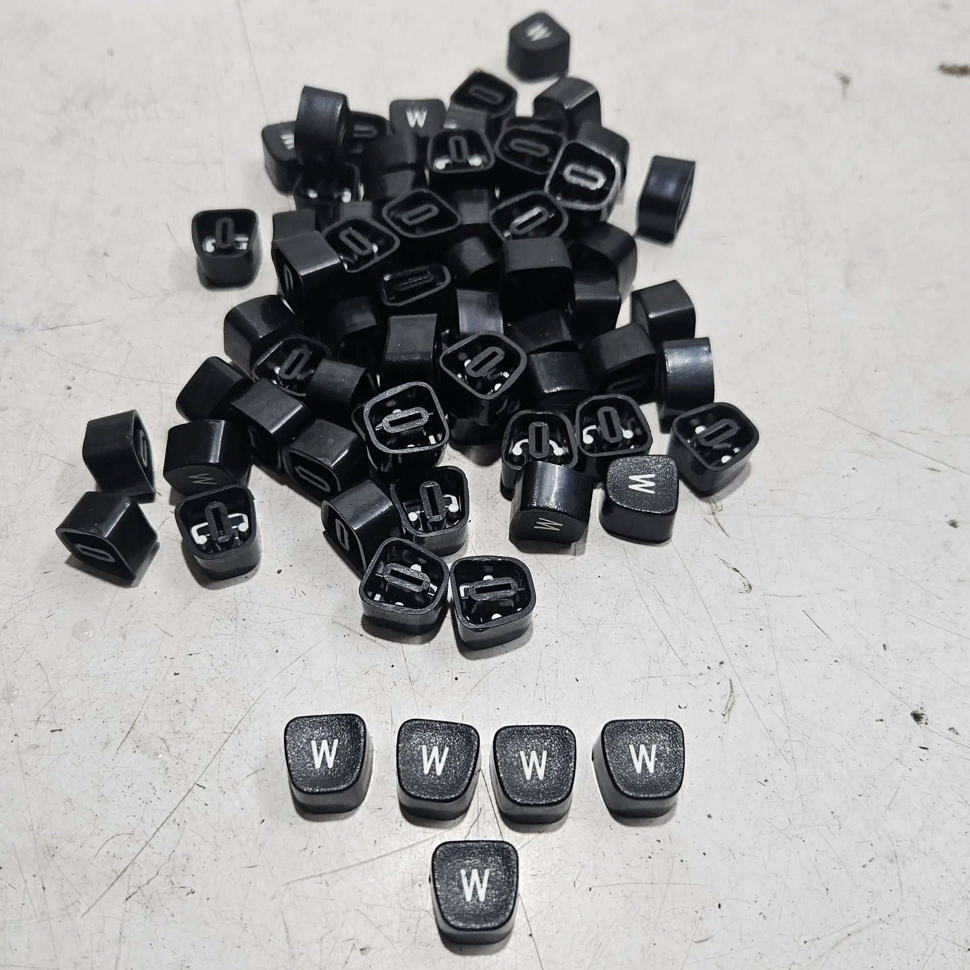 Close view of black W typewriter keytops used in typewriter restoration and typing machine maintenance projects