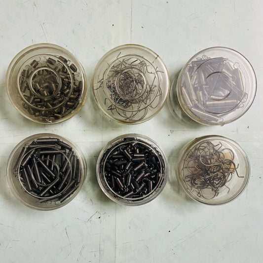 Assorted manual typewriter springs in storage containers for repair work, typewriter spare parts from RR Typewriter Mart