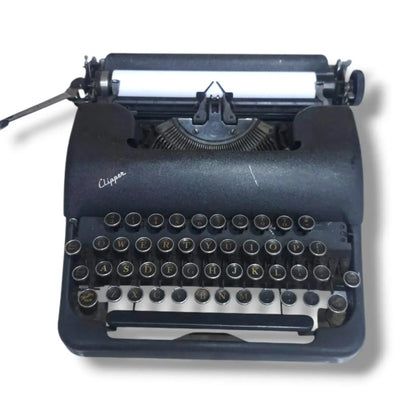 Smith Corona Clipper vintage typewriter front view with black body, round metal keys and classic American design
