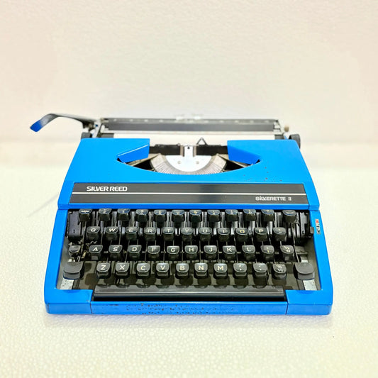 Front view of blue Silver Reed portable manual typewriter with English keyboard, for daily writing at RR Typewriter Mart