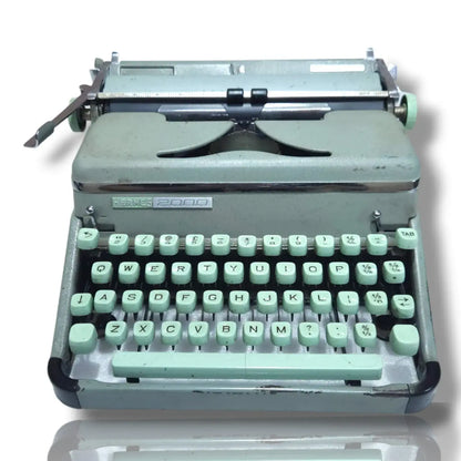 Vintage typewriter with a light green keyboard on a white background