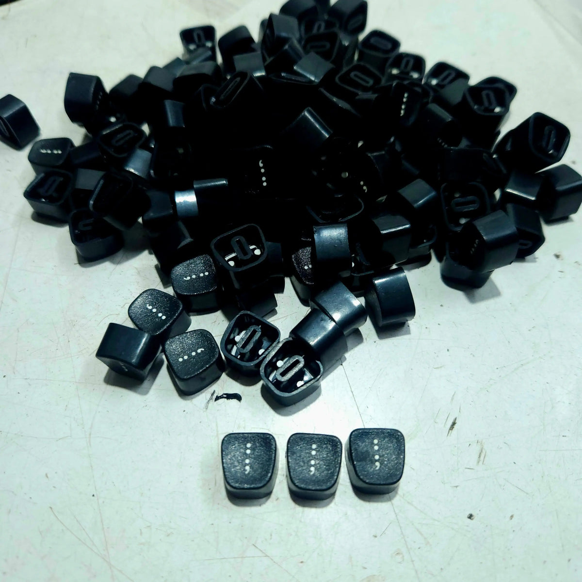 Black Godrej colon keytops displayed on a table, manual typewriter parts from RR Typewriter Mart for repair work