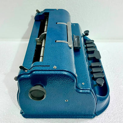 Elevated view of a blue Perkins Brailler typewriter showing carriage and keys, ideal to Buy Braille Typewriter from RR Typewriter Mart