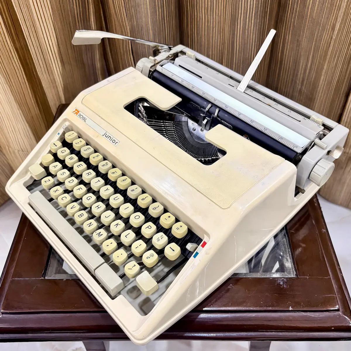 Royal Junior portable typewriter angled side view with cream housing, carriage and keyboard, from RR Typewriter Mart.