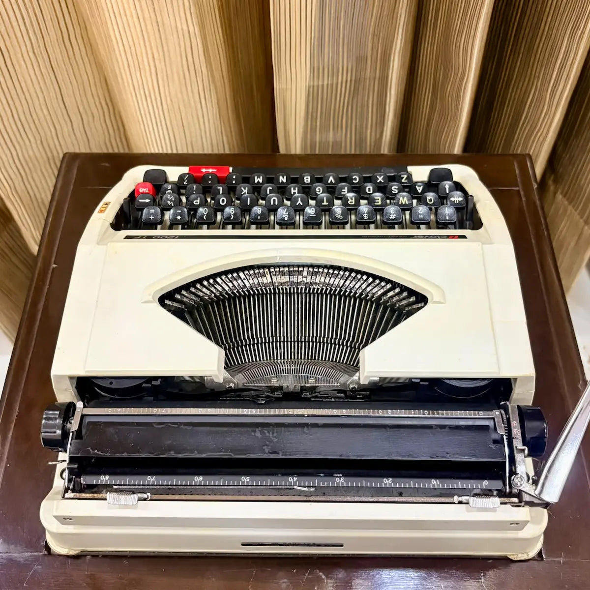 Clover 1200 TF typewriter front view, compact cream manual writing machine with distinctive red controls