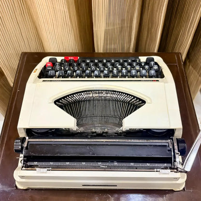 Clover 1200 TF typewriter front view, compact cream manual writing machine with distinctive red controls