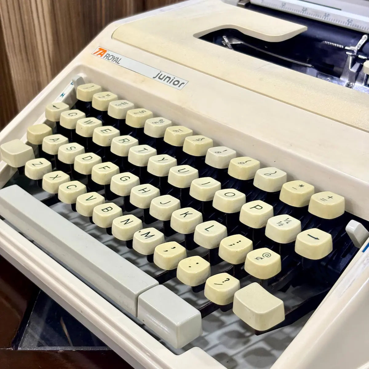 Royal Junior typing machine close-up showing English QWERTY keyboard and cream housing, from RR Typewriter Mart.