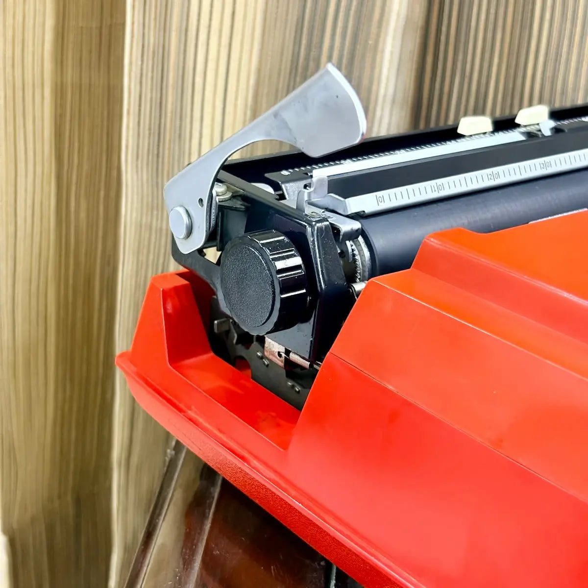 Brother Young Elite 513 manual typewriter with red casing, close-up of carriage knobs and platen assembly for typing | RR Typewriter Mart