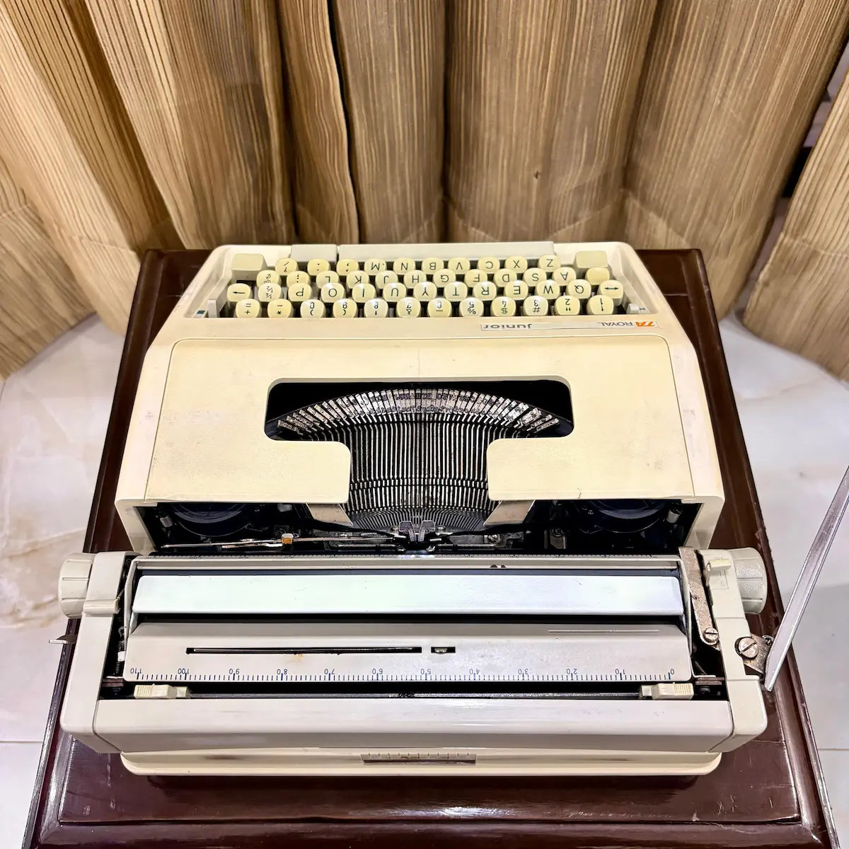 Royal Junior semi portable typewriter front view showing cream body, exposed typebars and carriage, from RR Typewriter Mart.