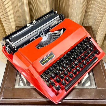 Brother Young Elite 513 red portable typewriter photographed from above, showing English keyboard and mechanical typebars | RR Typewriter Mart
