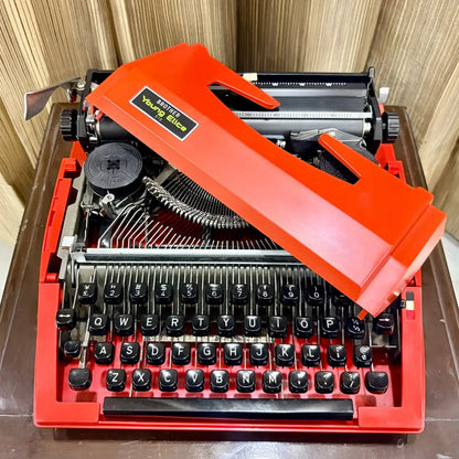 Side view of scarlet red Brother Young Elite 513 manual typewriter, highlighting portable design and vintage typewriter body | RR Typewriter Mart