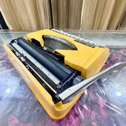 Angled rear view of Olivetti Lettera 82 yellow portable manual typewriter, showing typebars, platen and metal carriage for vintage typing at RR Typewriter Mart