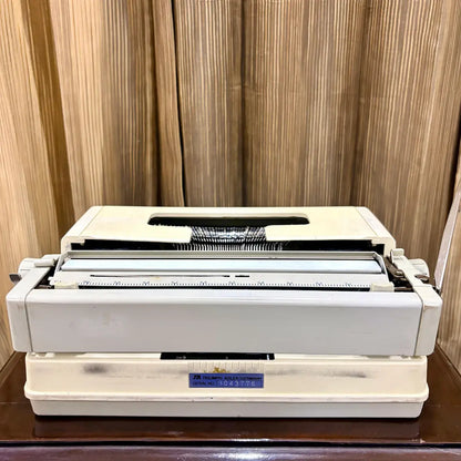 Royal Junior portable typewriter rear view showing cream housing and hard carrying case, from RR Typewriter Mart.