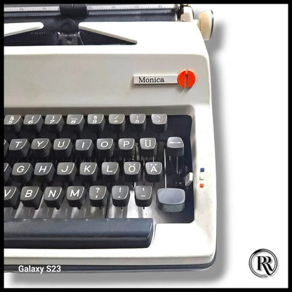 Olympia Monica typewriter close-up showing black keyboard, model badge and ivory body on vintage typing machine