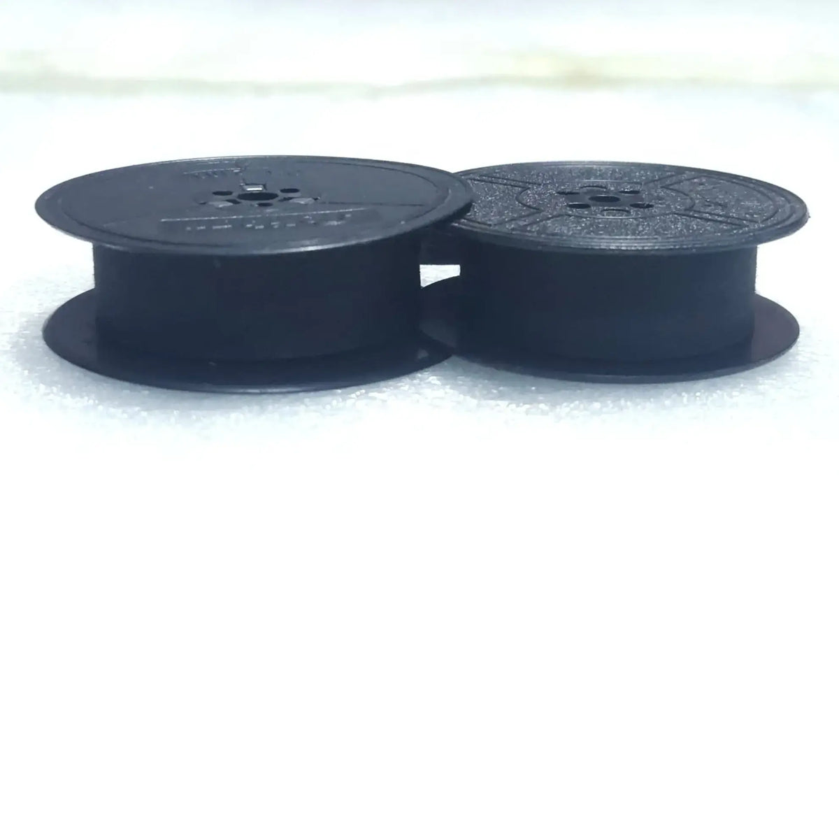Side profile of black typewriter ribbon roll spools, manual typewriter ribbons for typing machine use