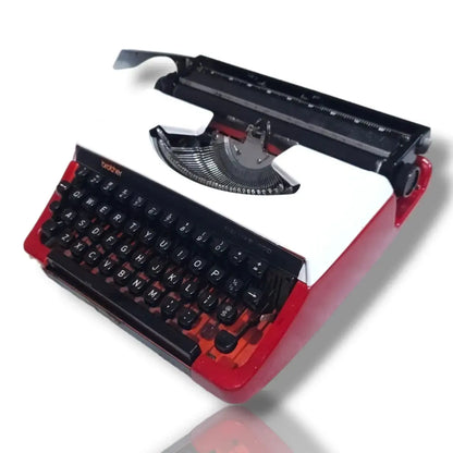Vintage Brother Deluxe 220 Swiss typewriter in red and white, angled view showing keyboard, typebars and carriage