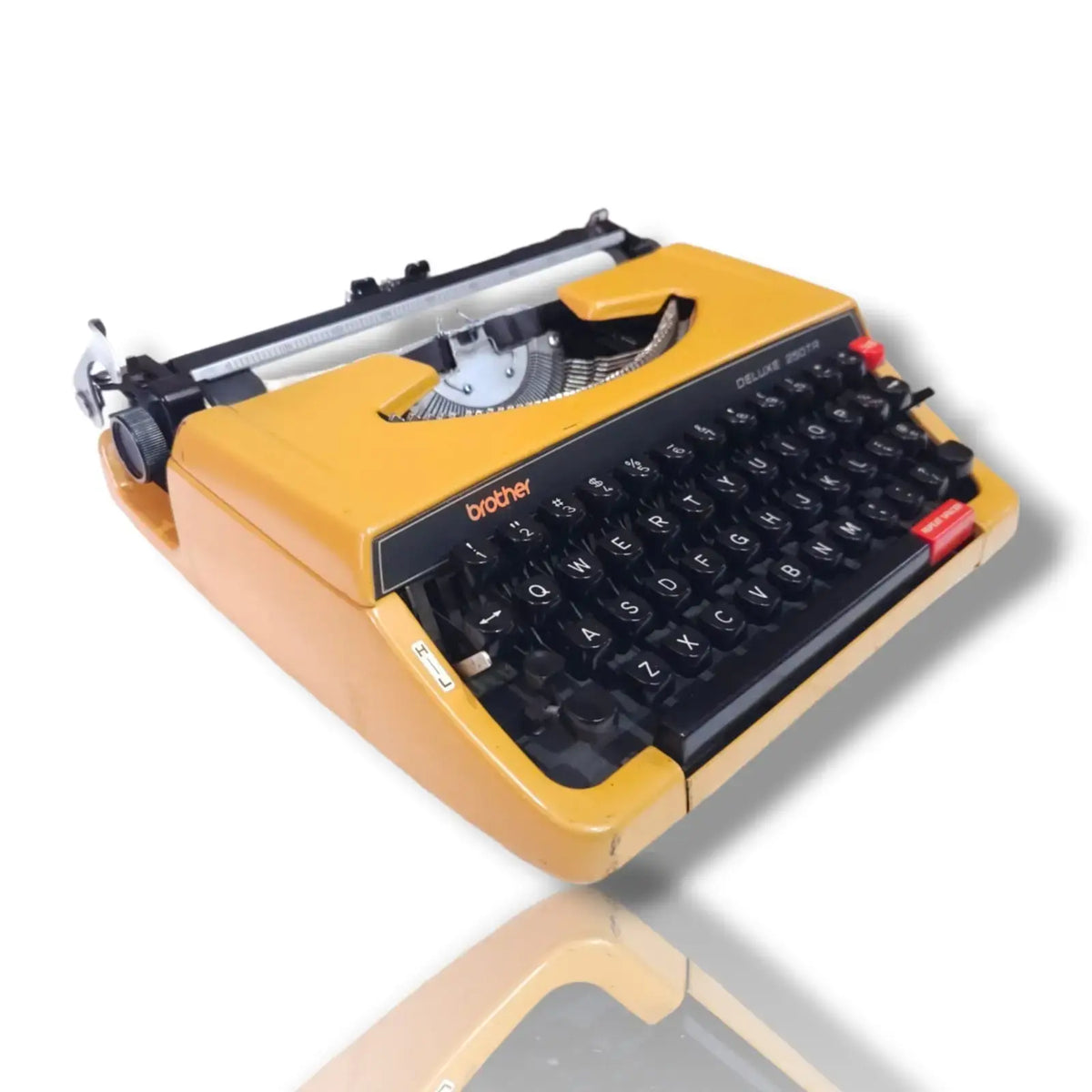 Brother Deluxe 250 TR Japanese typewriter angled view showing yellow body, black English keyboard and carriage