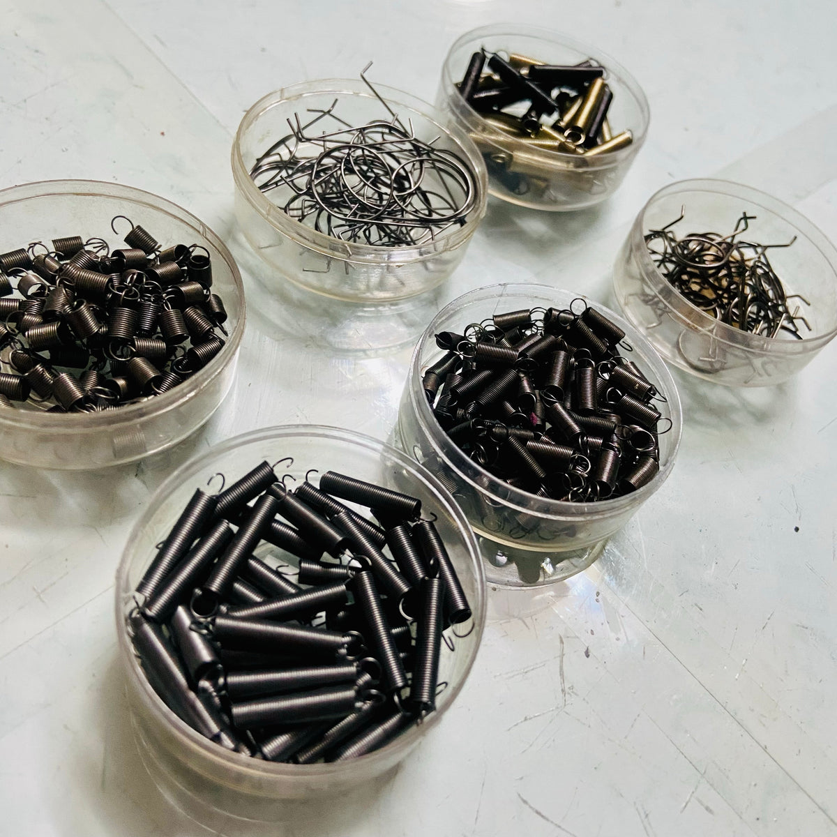 Mixed springs for typewriter repair and servicing displayed in containers, typing machine spare parts by RR Typewriter Mart